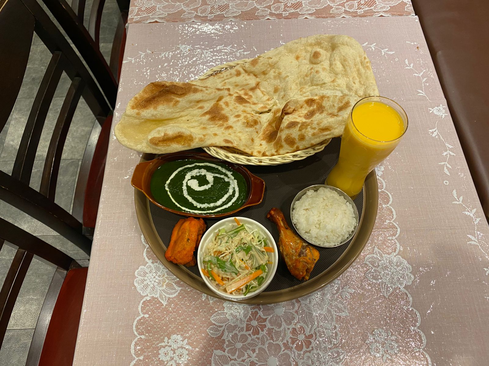 Restaurant set meal with naan, curry, rice, salad, and drink